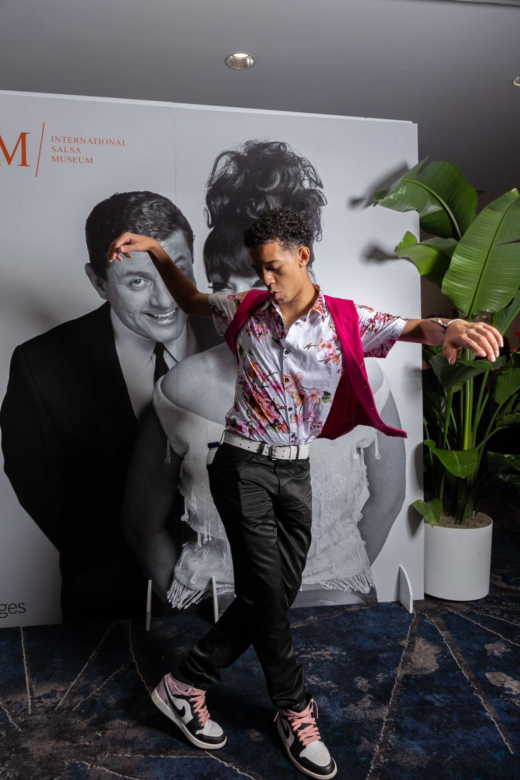 Dancer Josh Garcia performs in front of an International Salsa Museum exhibition